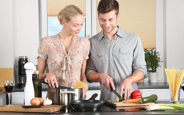 A couple cooks colorful vegetables in their kitchen, embracing Momfood Importantcool for healthy eating and togetherness.